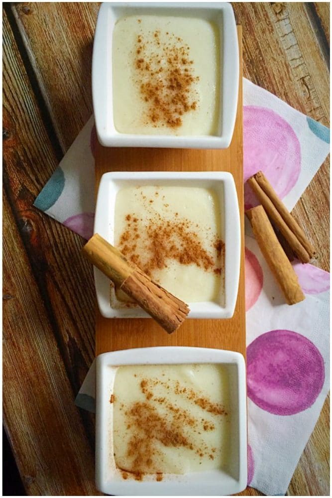 Overhead shoot of 3 small bowls of semolina pudding with ground cinnamon on top