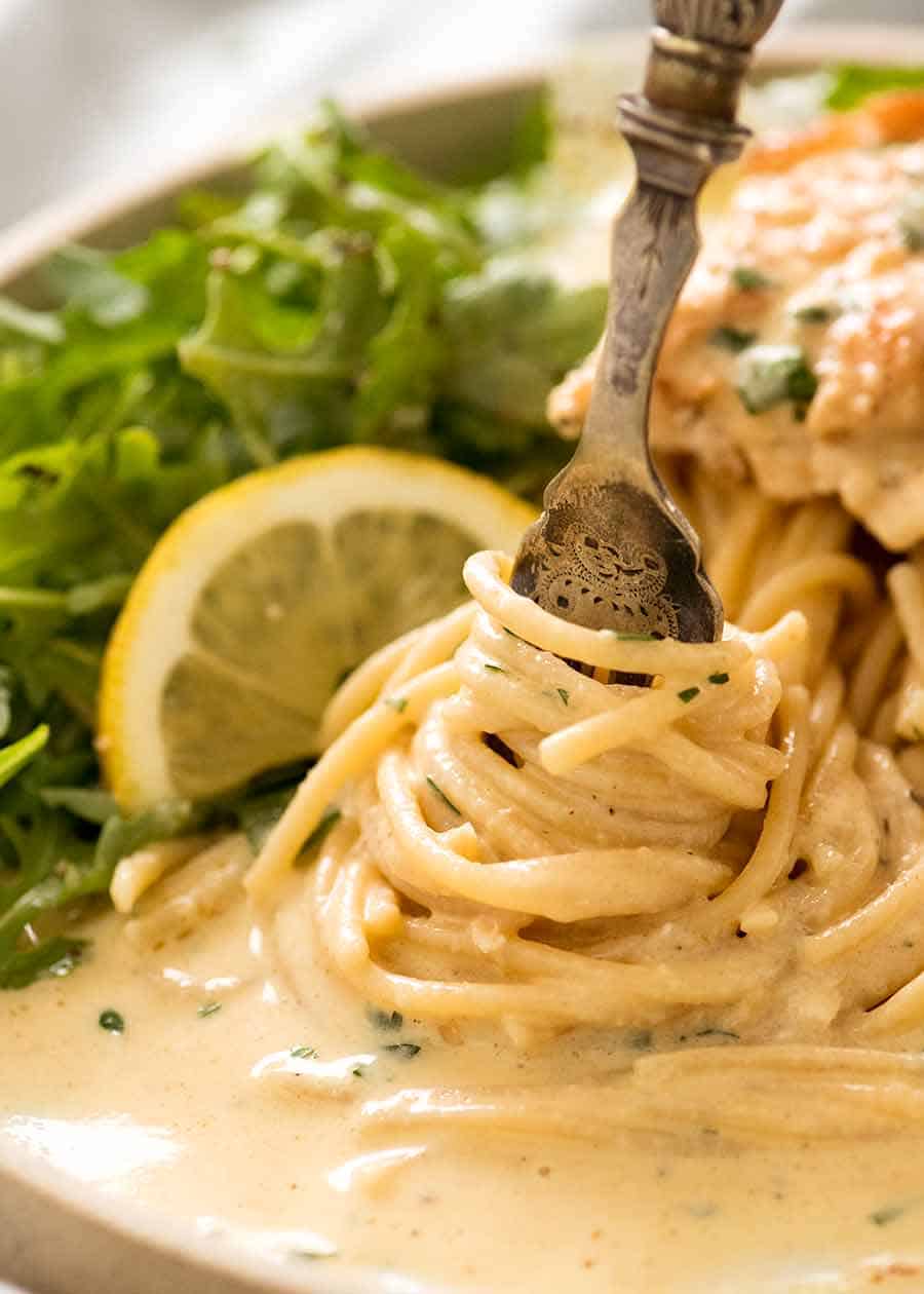 Fork twirling pasta coated with creamy lemon sauce from Creamy Lemon Chicken Breast