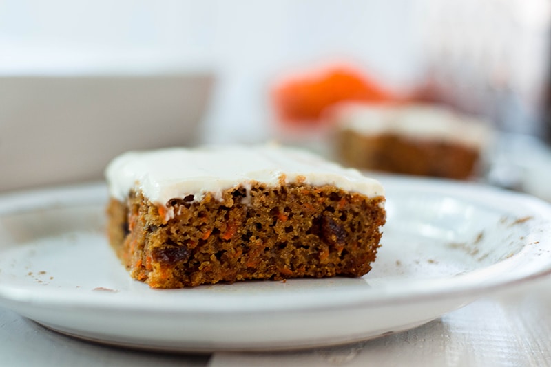Healthy carrot cake topped with greek yogurt frosting, sliced and ready to be served 