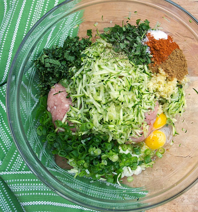 a bowl of ground turkey, shredded zucchinil, herbs, spices and an egg, ingredients for Ottolenghi