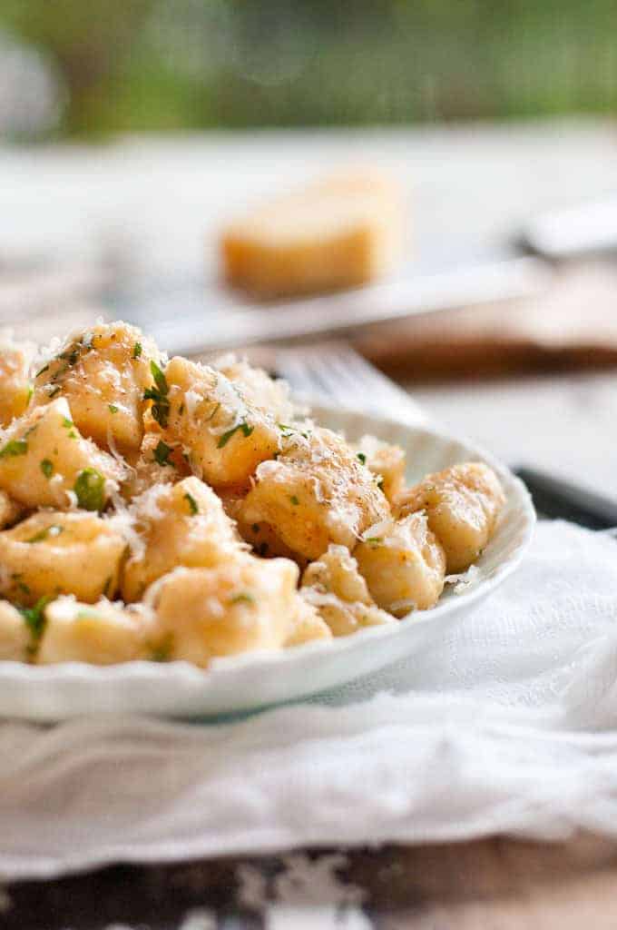 Plated ricotta gnocchi topped with grated parmesan
