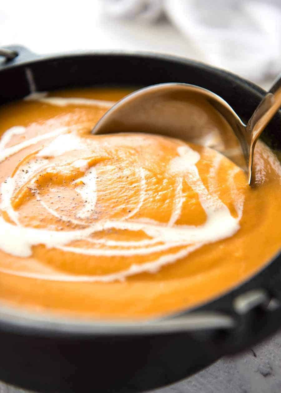 Thick and creamy pumpkin soup in a black cast iron pot, fresh off the stove, ready to be served.